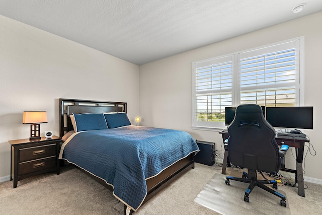 bedroom with light carpet and a textured ceiling