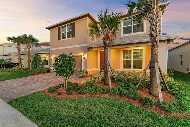 view of front of house featuring a garage and a lawn