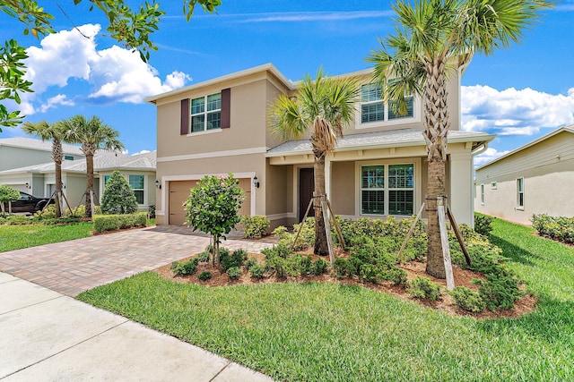 10312 SW Green Turtle Ln, Port Saint Lucie, FL 34987 - traditional-style home with stucco siding, decorative driveway, an attached garage, and a front yard