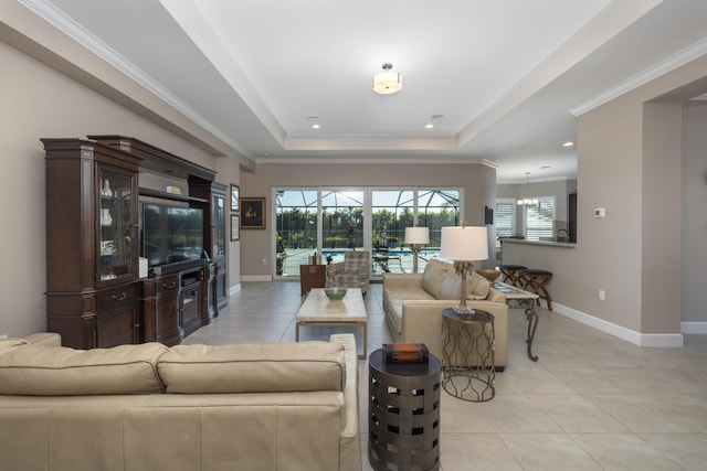 living room with a raised ceiling, light tile patterned floors, and crown molding