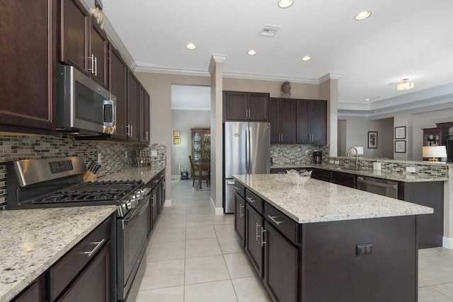 kitchen with a kitchen island, stainless steel appliances, backsplash, and crown molding