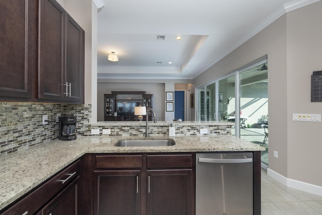 kitchen featuring kitchen peninsula, dishwasher, decorative backsplash, a tray ceiling, and sink