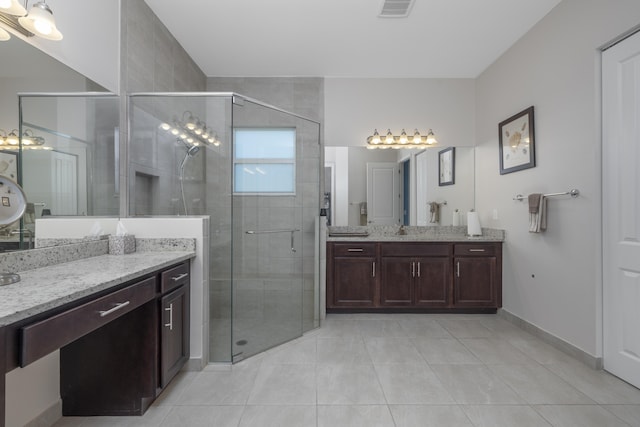 bathroom with tile patterned flooring, a shower with door, and vanity