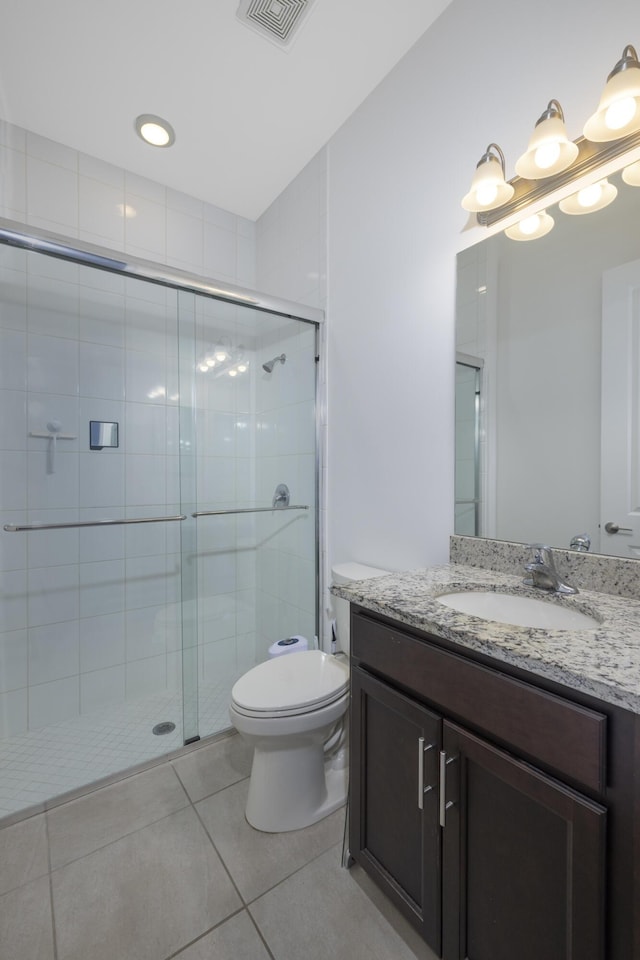 bathroom with tile patterned flooring, toilet, vanity, and a shower with shower door