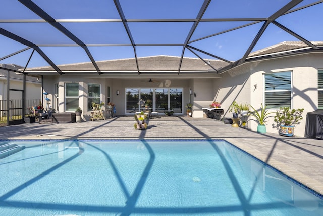 view of pool with ceiling fan, a lanai, and a patio area