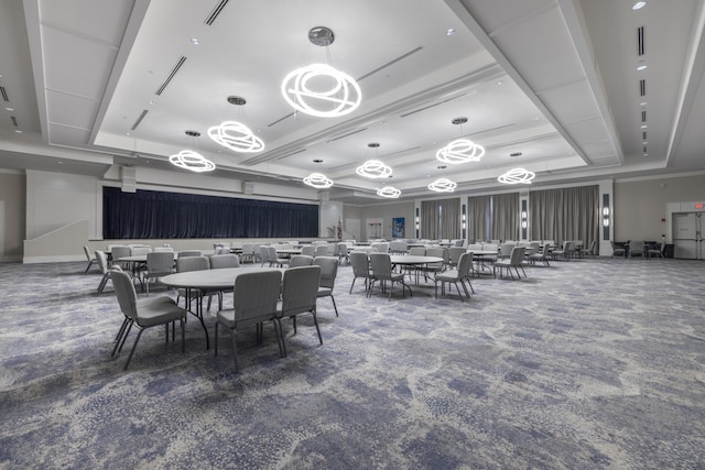 dining area with carpet floors and a tray ceiling