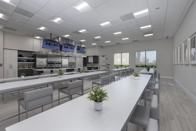 dining area with a towering ceiling and a drop ceiling