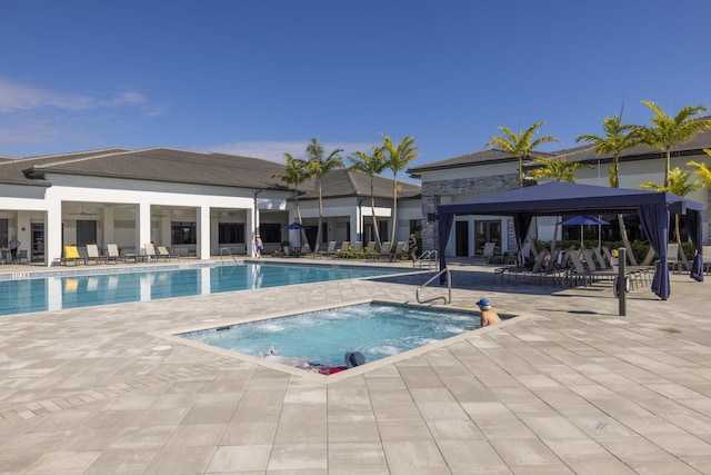 view of pool featuring a community hot tub and a patio area