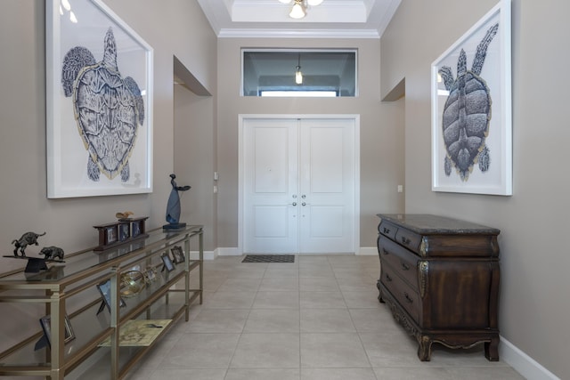 foyer featuring a towering ceiling, ornamental molding, and light tile patterned flooring