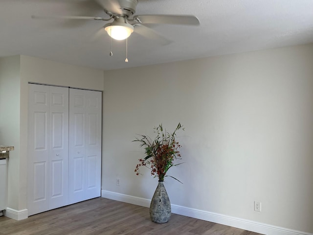 unfurnished bedroom with ceiling fan, hardwood / wood-style floors, and a closet