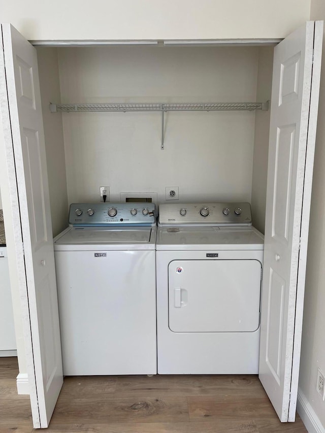 washroom featuring wood-type flooring and washing machine and dryer