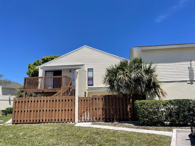 view of front of property with a front yard and a deck