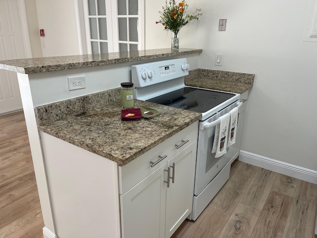 kitchen with white range with electric stovetop, white cabinetry, light hardwood / wood-style floors, and kitchen peninsula