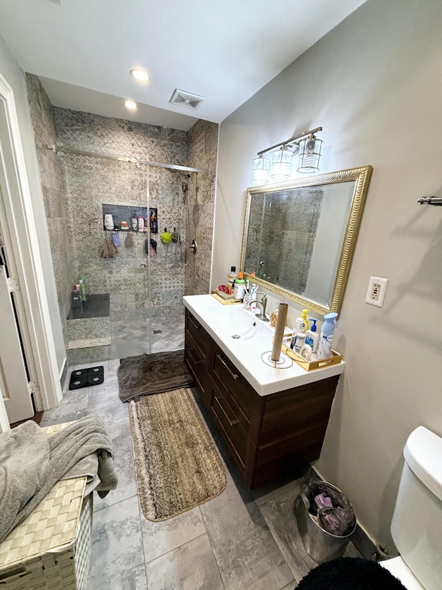 bathroom featuring tiled shower, vanity, and toilet