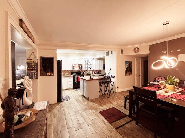 dining space with ornamental molding and light wood-type flooring