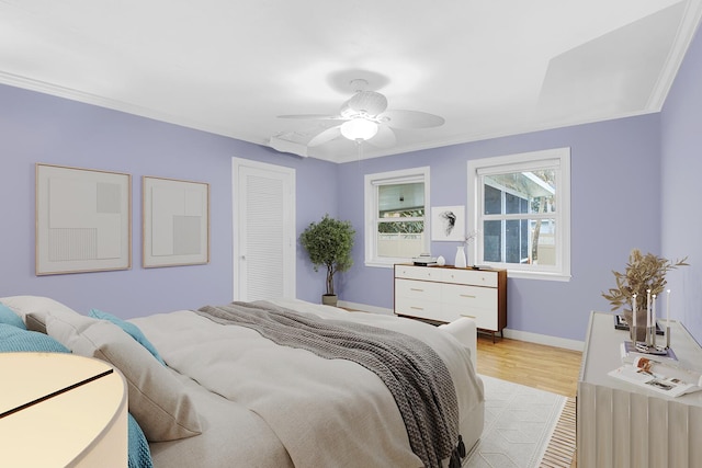 bedroom featuring ceiling fan, ornamental molding, and light hardwood / wood-style flooring