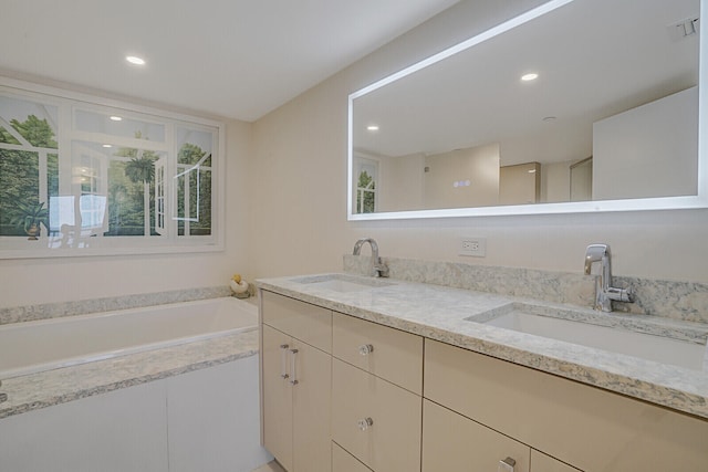 bathroom featuring a relaxing tiled tub and vanity