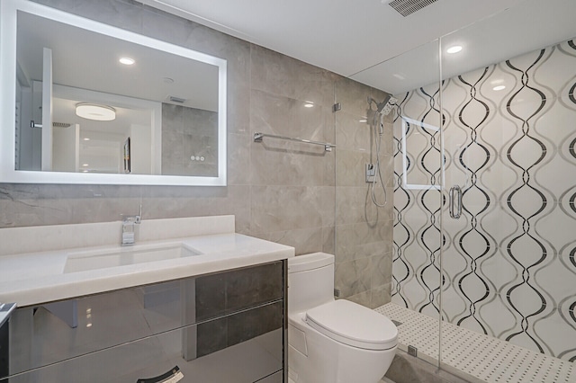 bathroom featuring an enclosed shower, vanity, tile walls, and toilet