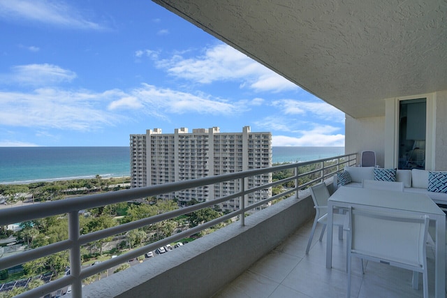 balcony featuring an outdoor living space and a water view