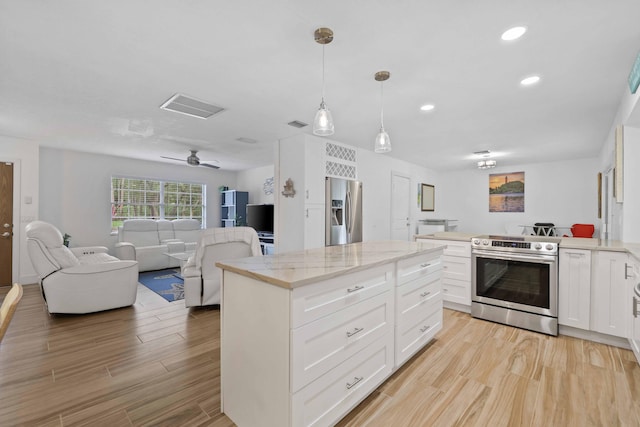 kitchen with hanging light fixtures, white cabinets, light stone countertops, and stainless steel appliances