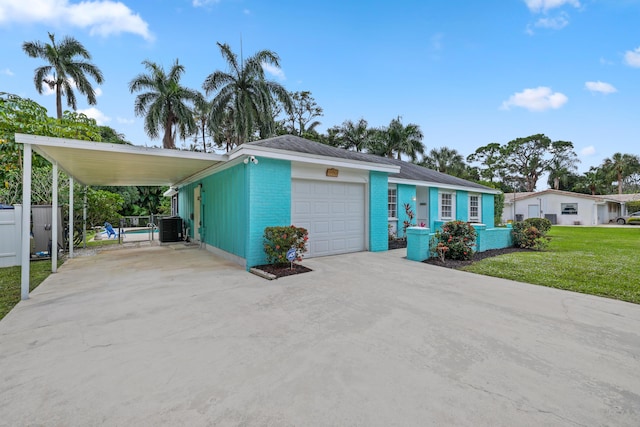 view of front facade featuring a garage, a front lawn, a carport, and central AC