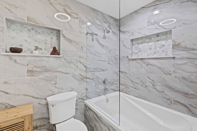 bathroom featuring toilet and tiled shower / bath