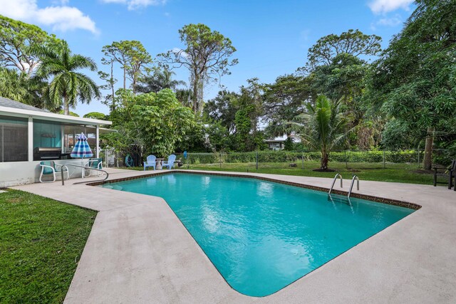 view of pool featuring a lawn and a patio area