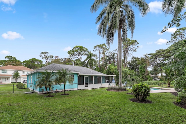 rear view of property with a sunroom and a lawn