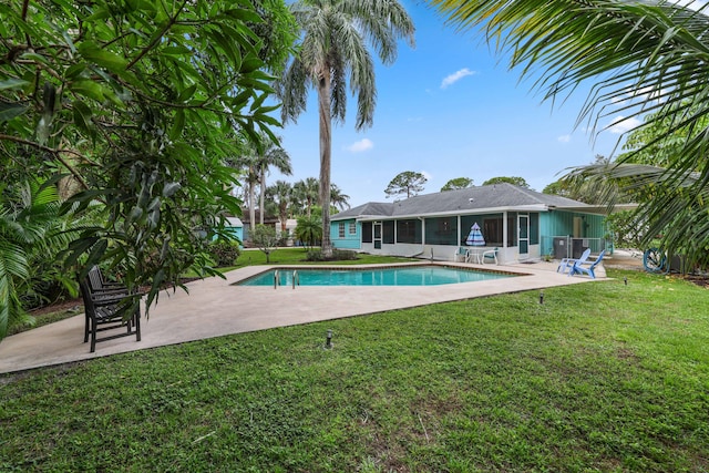 view of pool with a patio area and a lawn