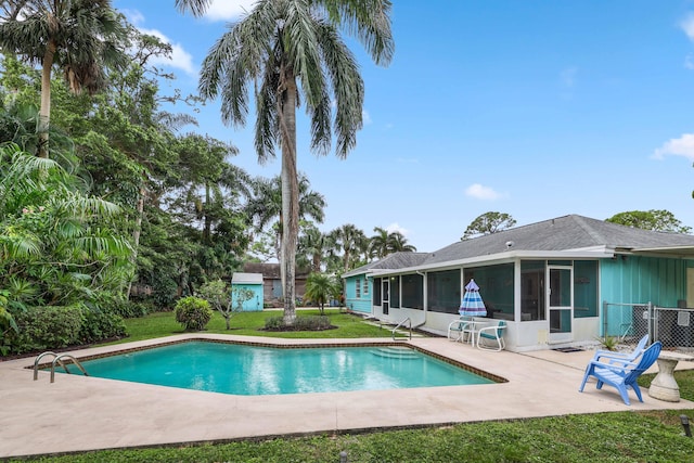 view of swimming pool with a sunroom, a yard, and a patio