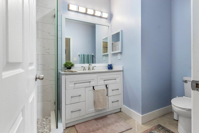 bathroom featuring tile patterned floors, vanity, a tile shower, and toilet