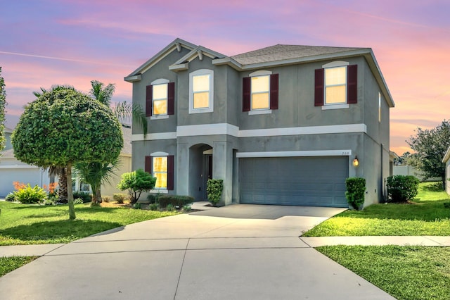 view of front of house featuring a garage and a lawn