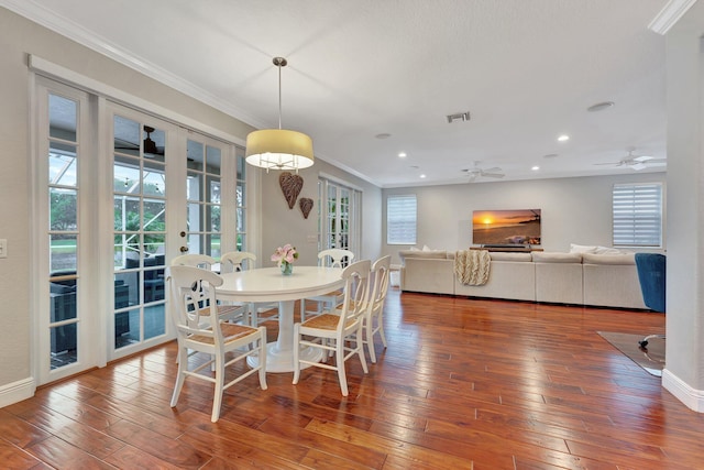 dining room with wood-type flooring, ornamental molding, and ceiling fan