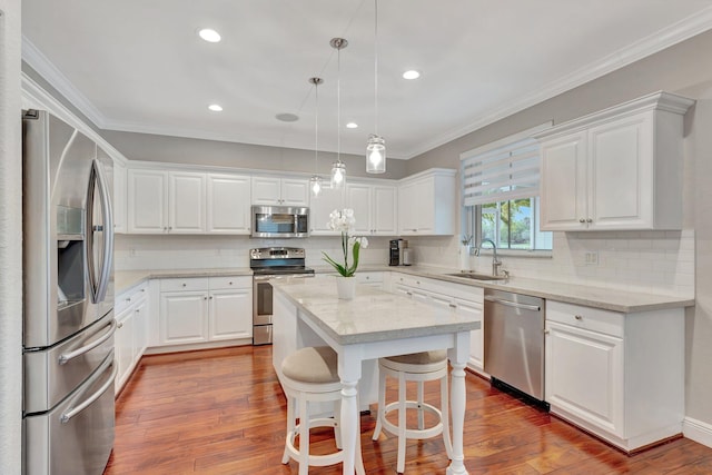 kitchen featuring white cabinetry, a center island, appliances with stainless steel finishes, and sink