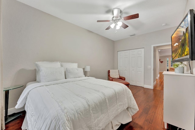 bedroom with a closet, dark hardwood / wood-style floors, and ceiling fan