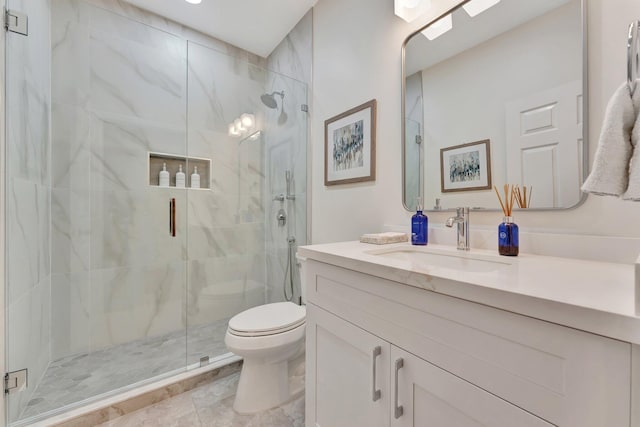 bathroom featuring vanity, a shower with door, and toilet