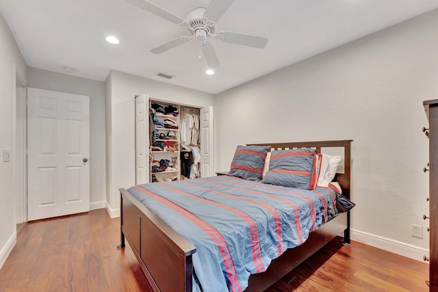 bedroom with hardwood / wood-style flooring, ceiling fan, and a closet