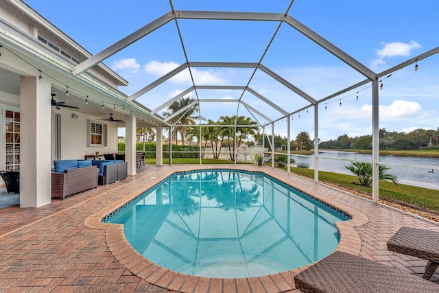 view of pool featuring a lanai, ceiling fan, outdoor lounge area, a patio, and a water view