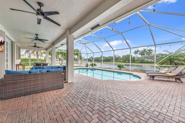 view of pool with ceiling fan, a patio, a water view, glass enclosure, and an outdoor living space