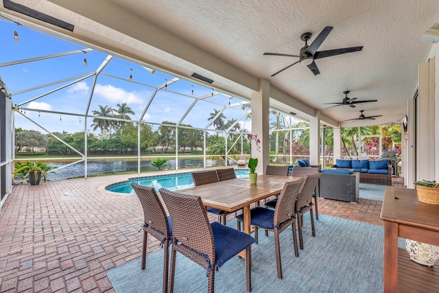 view of patio / terrace featuring a water view, ceiling fan, outdoor lounge area, and glass enclosure