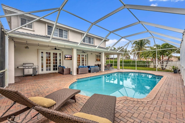 view of swimming pool with french doors, outdoor lounge area, a lanai, ceiling fan, and a patio