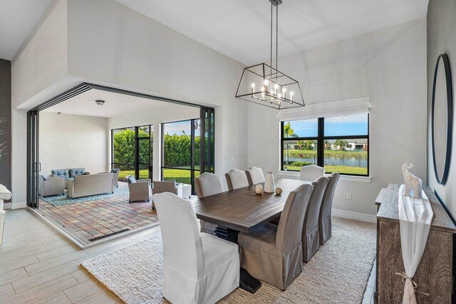 dining space with a water view and a chandelier