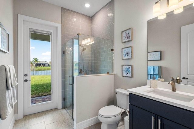 bathroom with an enclosed shower, vanity, a healthy amount of sunlight, toilet, and a water view