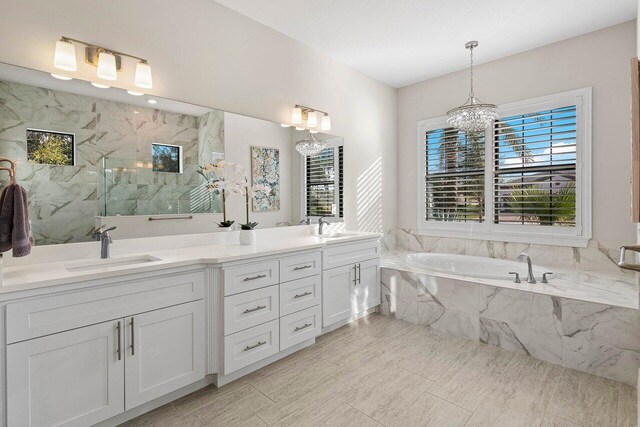 bathroom with vanity, a wealth of natural light, a chandelier, and shower with separate bathtub