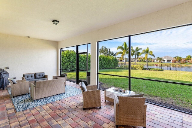 sunroom / solarium featuring a water view