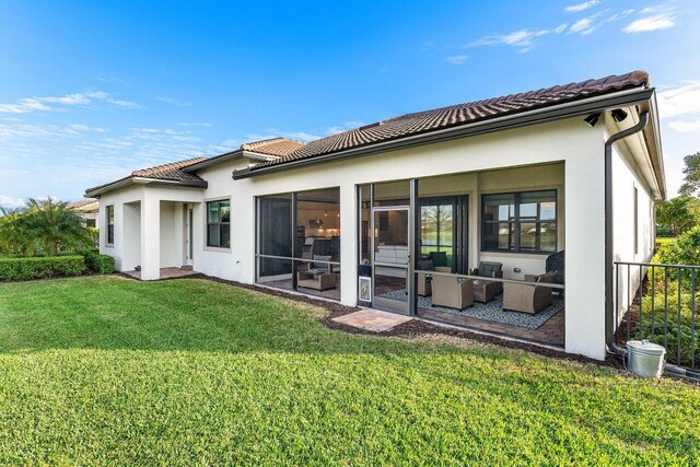 back of property with a yard and a sunroom