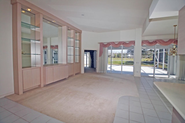 unfurnished living room featuring carpet floors and a notable chandelier