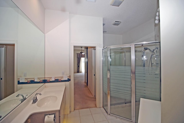 bathroom featuring a textured ceiling, tile patterned floors, vanity, and a shower with shower door