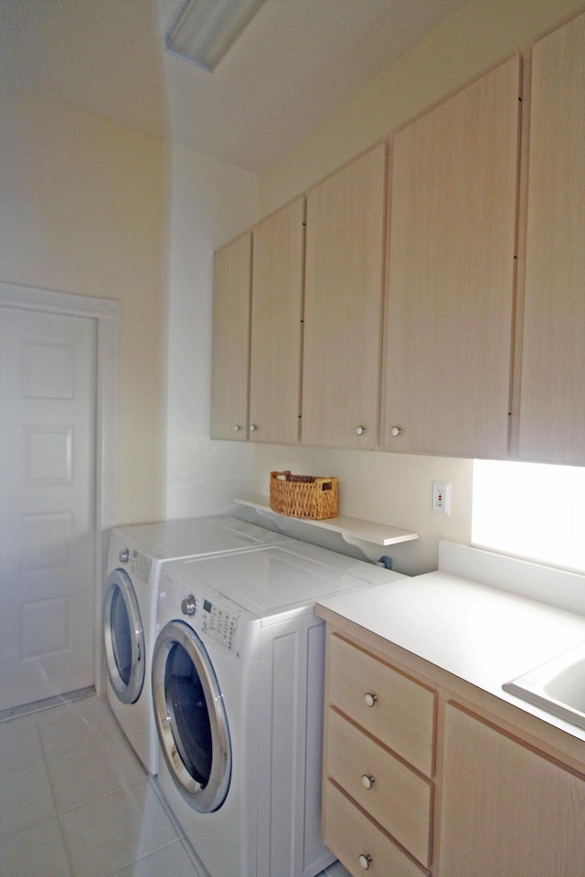 washroom featuring cabinets, light tile patterned floors, and independent washer and dryer