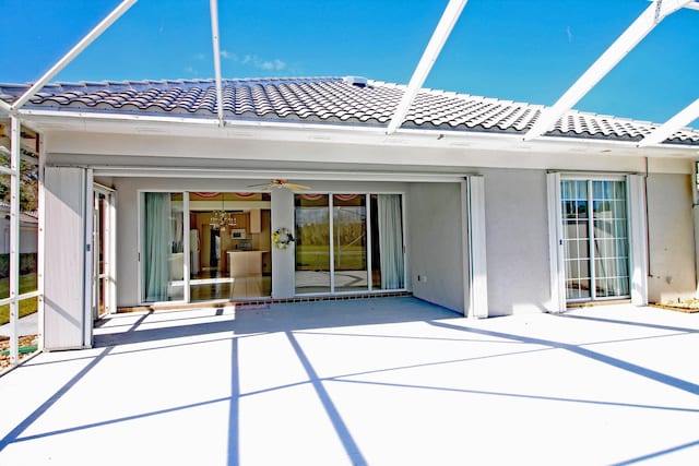 back of property with ceiling fan and a patio area